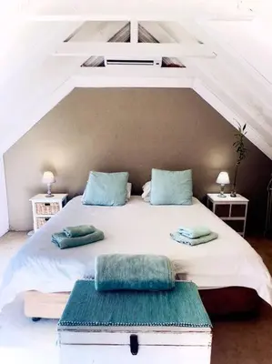 a bedroom with a large white bed with blue pillows at Tuscan Farmhouse near Franschhoek in Simondium