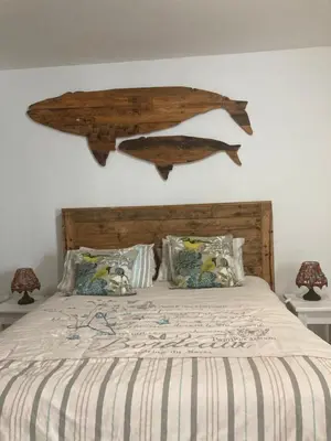 a bed with a wooden headboard with two fish on the wall at Budget Boutique in Blomtuin