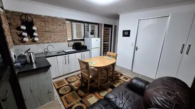 a kitchen with a table and a kitchen with a couch at Budget Boutique in Blomtuin
