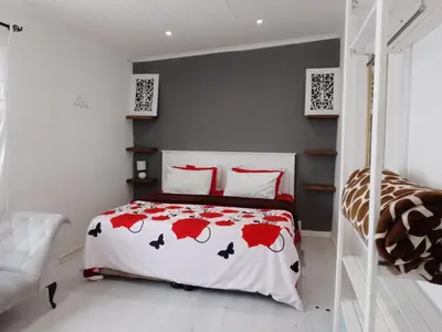 a bedroom with a bed with red flowers on it at ggu in Cape Town