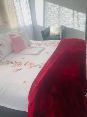 a bed with a red blanket on top of it at ggu in Cape Town