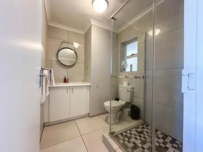 a bathroom with a toilet and a glass shower at Century Hideaway with Mountain views, Security, FREE Parking in Cape Town