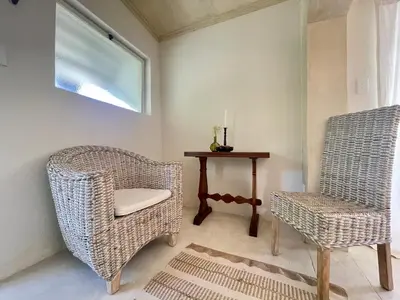 a room with two wicker chairs and a table at La Rose Quartier in Wellington