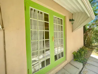 a green door on the side of a house at La Rose Quartier in Wellington