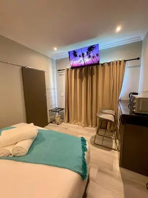 a bedroom with a bed and a television on the wall at Tehillah on Boom in Bothasig