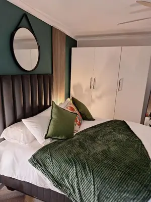 a bedroom with a bed with a mirror on the wall at Dee-Ones at Witboom,Kenridge ,Self Catering Apartment in Kenridge