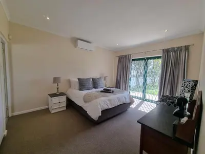 a bedroom with a bed and a large window at The Nook in Stellenbosch