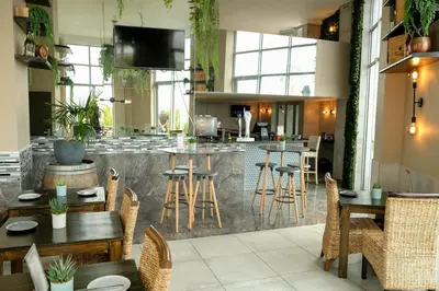 a restaurant with tables and chairs and a bar at Sunset Accommodation in Strand in Strand