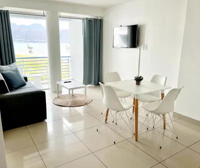 a living room with a white table and chairs at Sunset Accommodation in Strand in Strand
