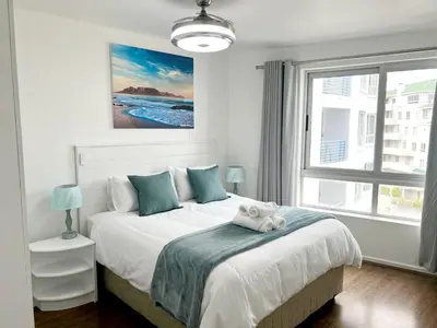 a bedroom with a bed with a teddy bear on it at Sunset Accommodation in Strand in Strand