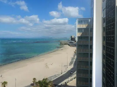 a view of the beach from the balcony of a building at Sunsets on Beach Strand in Cape Town