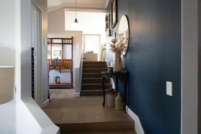 a hallway with a blue wall and a staircase at De Boerderij in Strand