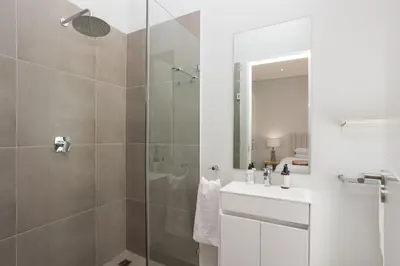 a bathroom with a shower and a sink and a mirror at Luxury Villa 712 Pearl Valley Golf Estate in Paarl