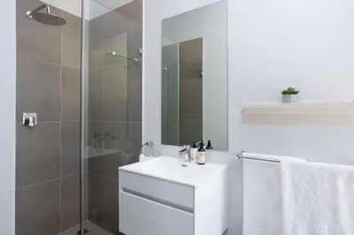 a white bathroom with a sink and a shower at Luxury Villa 712 Pearl Valley Golf Estate in Paarl