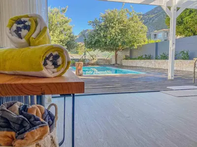 a view of a swimming pool from a table with a towel at Chanteclair Re-Energised 1 Bed 1 Bath in Hermanus