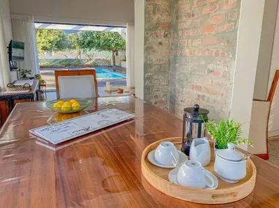 a wooden table with a tea set on top of it at Chanteclair Re-Energised 1 Bed 1 Bath in Hermanus