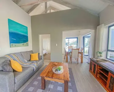 a living room with a couch and a table at Chanteclair Re-Energised 1 Bed 1 Bath in Hermanus