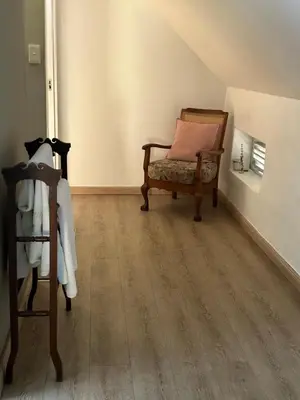 a room with a chair with a pillow on it at Koetshuis on High Street in Paarl