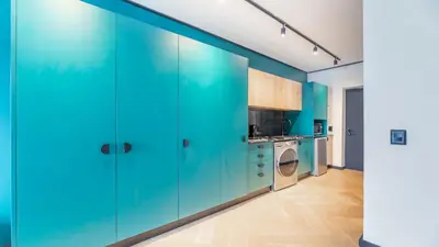 a kitchen with green cabinets and a washer and dryer at Little island in Cape Town