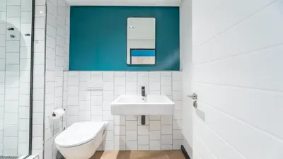 a white bathroom with a sink and a toilet at Little island in Cape Town