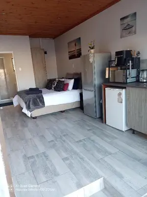 a bedroom with a bed and a refrigerator at Jennings breeze in Cape Town