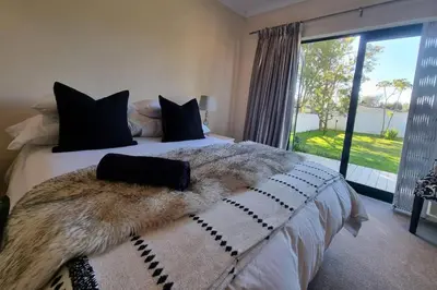 a bedroom with a large bed with a large window at Paradyskloof home in Stellenbosch