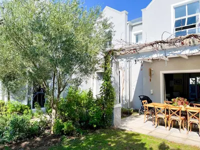 a patio with a wooden table and chairs at Duplicate in Franschhoek