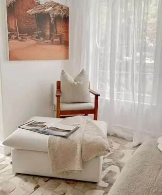 a bedroom with a bed and a chair and a window at Duplicate in Franschhoek