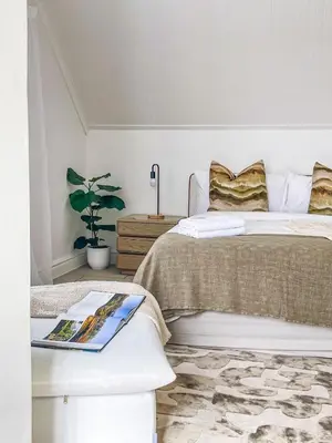 a bedroom with a bed and a book on a table at Duplicate in Franschhoek
