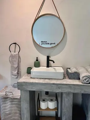 a bathroom sink with a mirror on top of it at Die Klein Huis in Cape Town