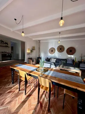 a living room with wooden tables and a couch at Die Klein Huis in Cape Town