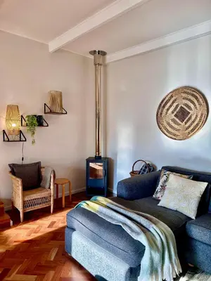 a living room with a blue couch and a stove at Die Klein Huis in Cape Town