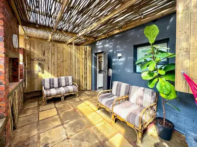 a living room with two chairs and a plant at Amsterdam Suite in Cape Town