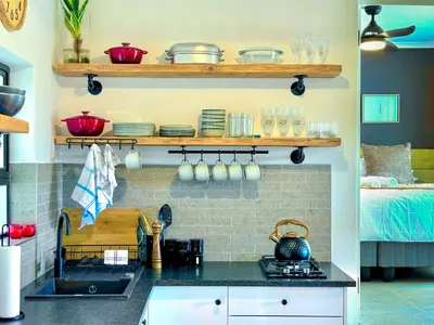 a kitchen with a counter with dishes on shelves at Amsterdam Suite in Cape Town