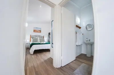 a white bathroom with a bed and a sink at Modern & Central 1 BR Apt Close To Major Attractions in Cape Town