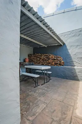 a patio with a table and a pile of logs at Modern & Central 1 BR Apt Close To Major Attractions in Cape Town
