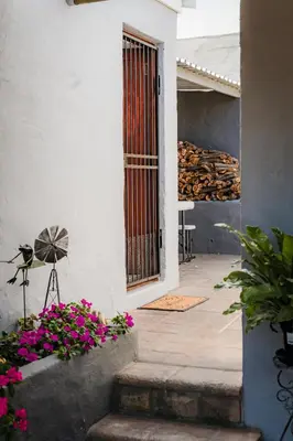 a door to a house with flowers and a table at Modern & Central 1 BR Apt Close To Major Attractions in Cape Town