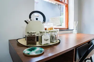 a table with a tea kettle and jars on it at Modern & Central 1 BR Apt Close To Major Attractions in Cape Town