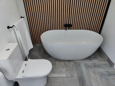 a bathroom with a white tub and a toilet at Gordon's Bay Sunset View in Cape Town