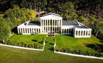 an aerial view of a large white building on a lawn at Manor House at La Roche Estate - Franschhoek in Franschhoek