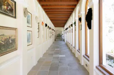 a hallway in a building with paintings on the walls at Manor House at La Roche Estate - Franschhoek in Franschhoek