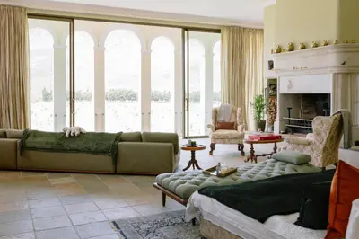 a living room with a couch and a fireplace at Manor House at La Roche Estate - Franschhoek in Franschhoek