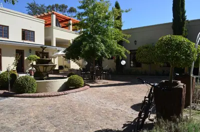 a courtyard with a fountain and a bike parked in front of a building at Cultivar Boutique Hotel in Stellenbosch