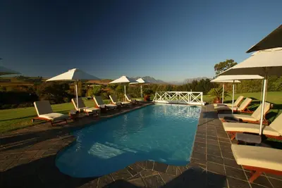 a swimming pool with lounge chairs and umbrellas at Cultivar Boutique Hotel in Stellenbosch