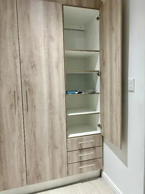 a wardrobe with wooden doors in a room at Garden Flat in Cape Town
