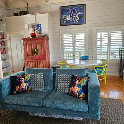 a living room with two blue couches and a table at MAGNIFICENT 6 sleeper mountain getaway in Romansrivier