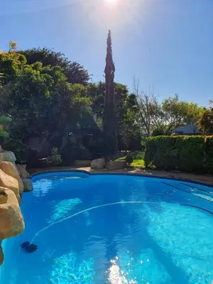 a large pool with blue water in a yard at TUSCAN VILLA FELICE near West Coast in Cape Town