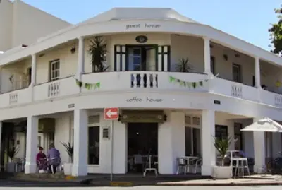 a white building with people sitting outside of it at Mill House Bed and Breakfast in Stellenbosch