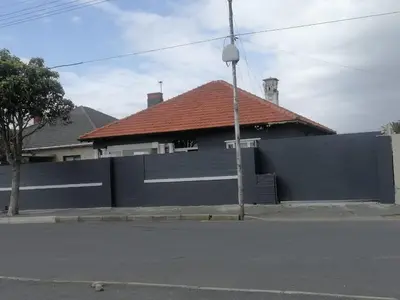 a house with a blue fence and a building at Exotica Central guest house in Cape Town