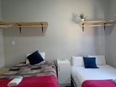 two beds sitting next to each other in a room at Exotica Central guest house in Cape Town